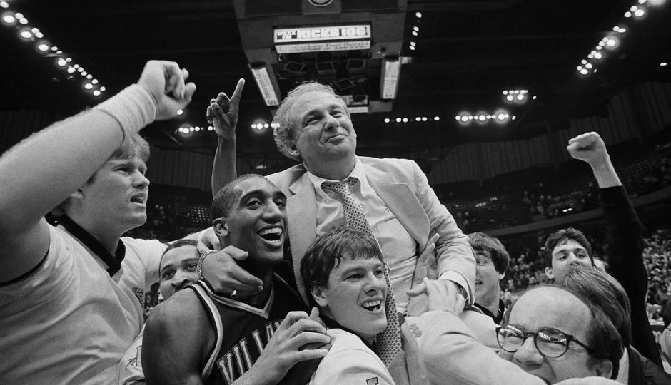 Celebration with basketball team and coach lifted.